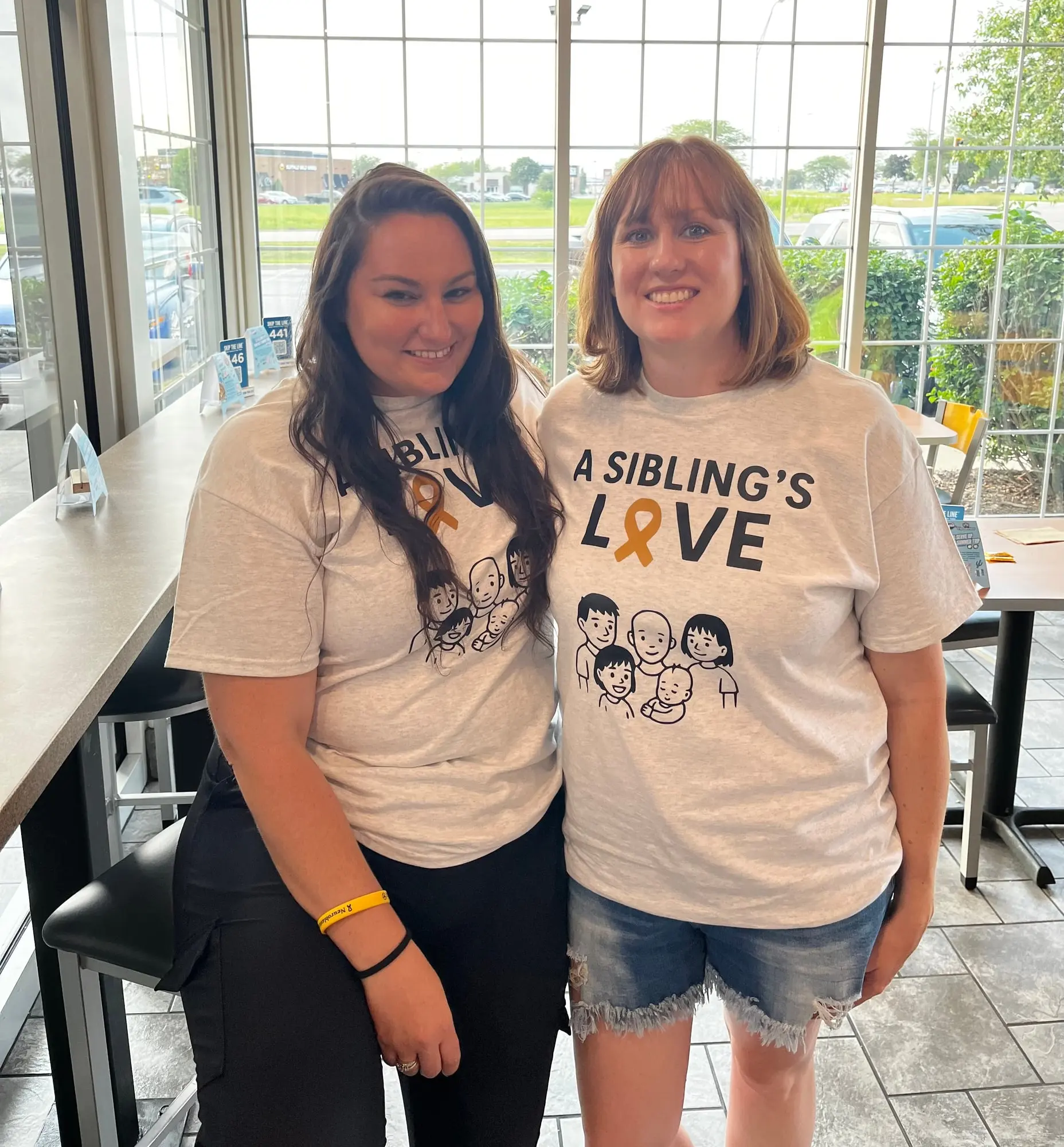 Gavin's mom and a supporter in A Sibling's Love shirts inside Culver's of Peru